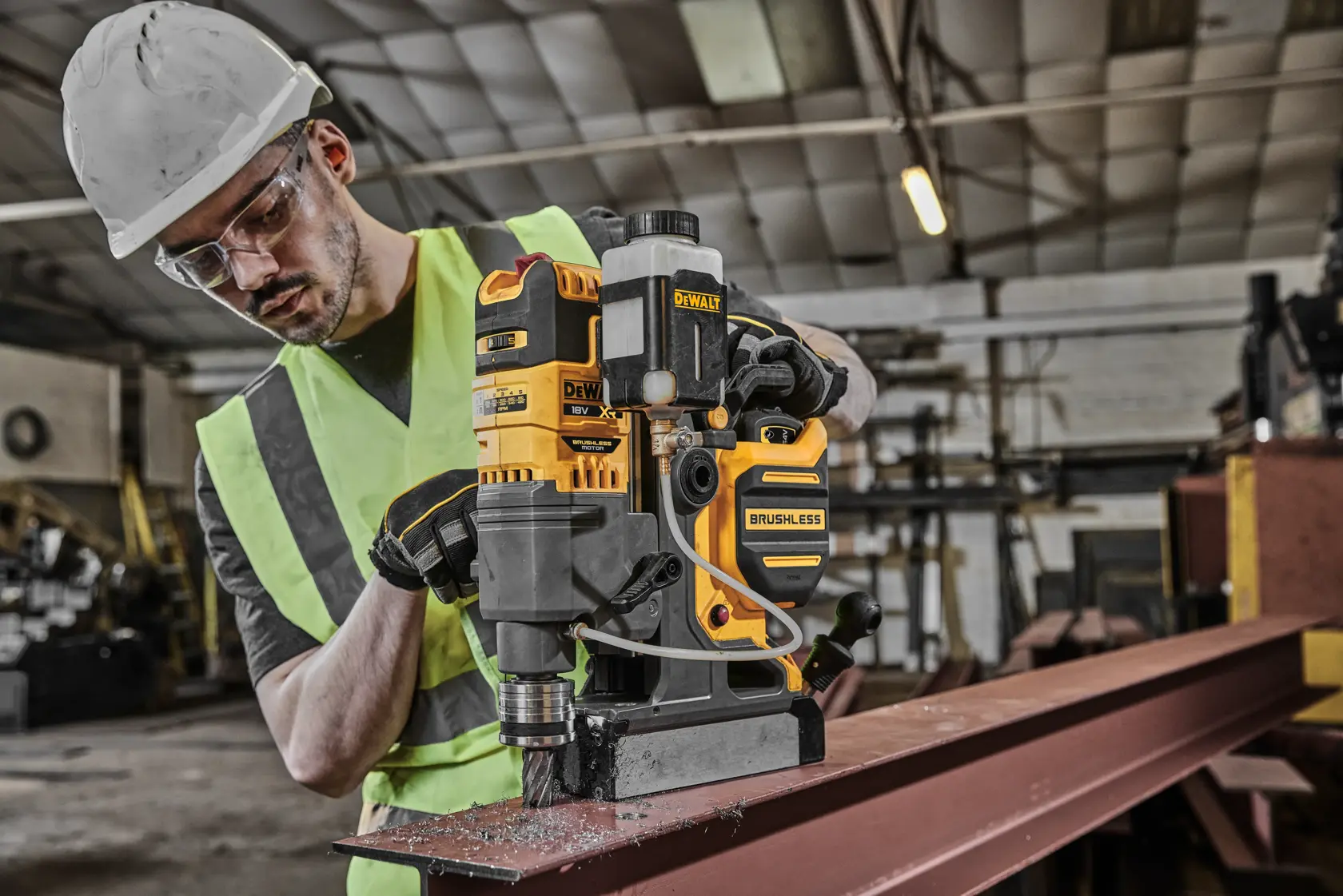 DEWALT DCD1623N Brushless-Bohrer im Einsatz auf Metallträger in Werkstatt, bedient von Person mit Schutzkleidung.