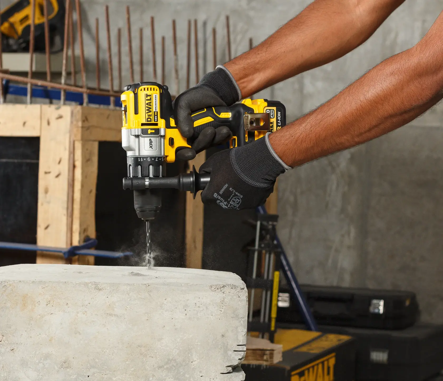 Persona usa taladro DEWALT inalámbrico para perforar concreto en obra, lleva guantes negros.