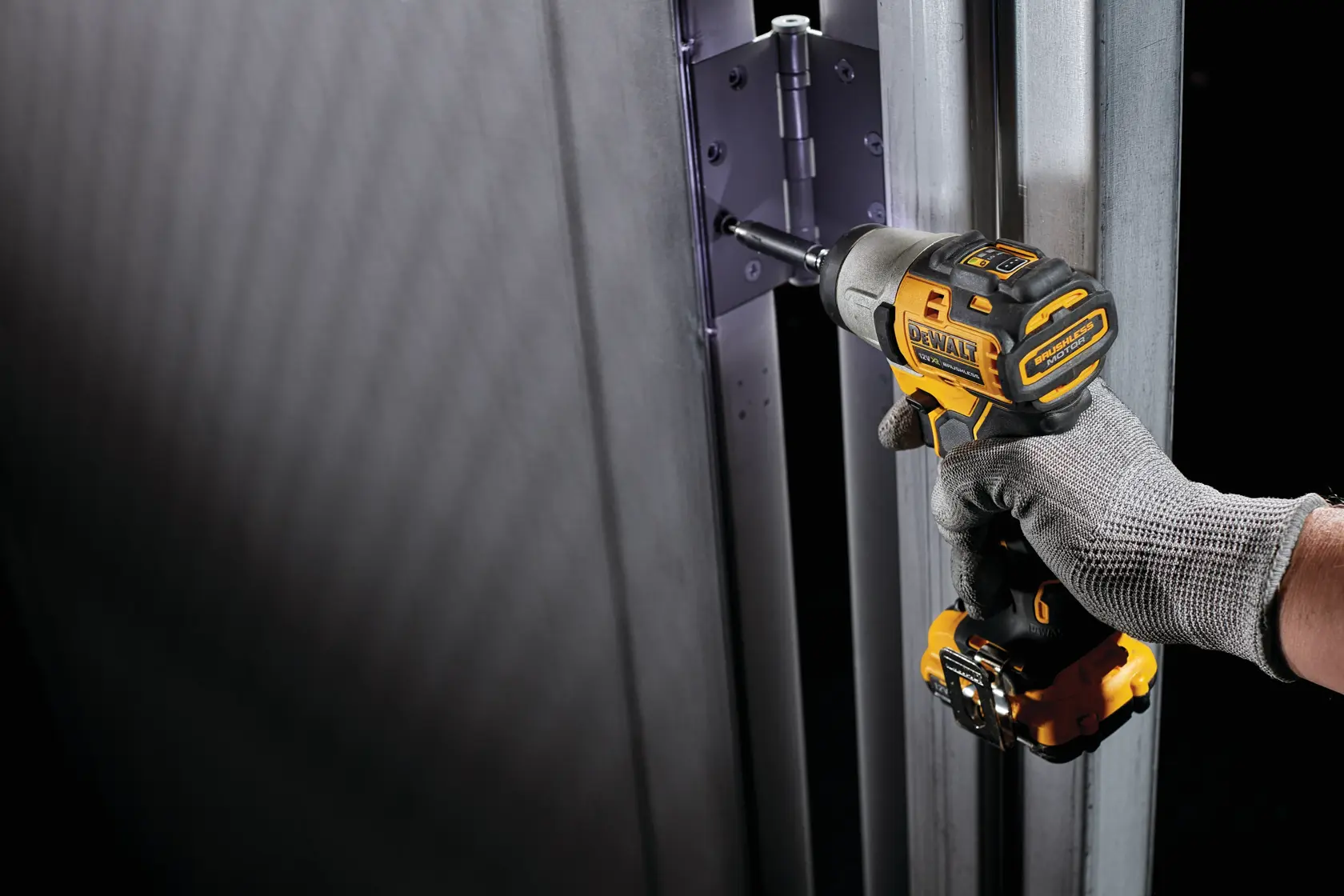 DEWALT DCK2111L2T-XE and DCF801N drill used on a metal door hinge. Photography product image.