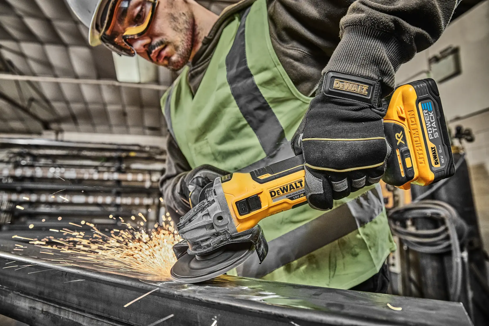 Worker uses DEWALT cordless grinder, producing sparks while grinding metal in an industrial environment.
