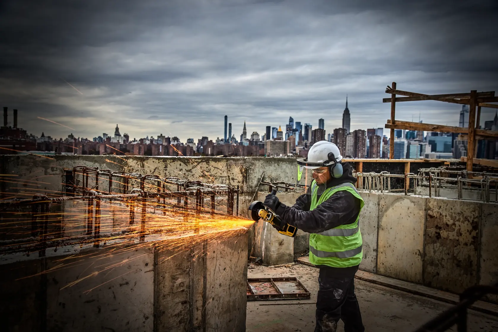Persona usa una amoladora inalámbrica DEWALT en un bloque de concreto, generando polvo.