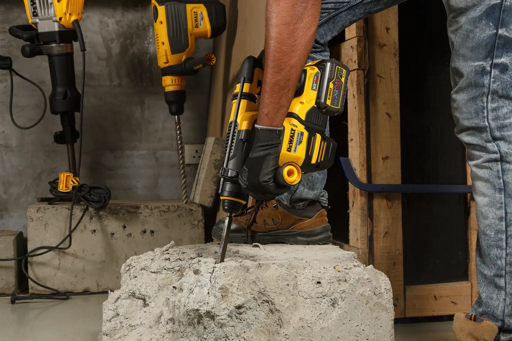 Persona usando martillo rotativo inalámbrico DEWALT DCH333NT en un bloque de concreto en obra.
