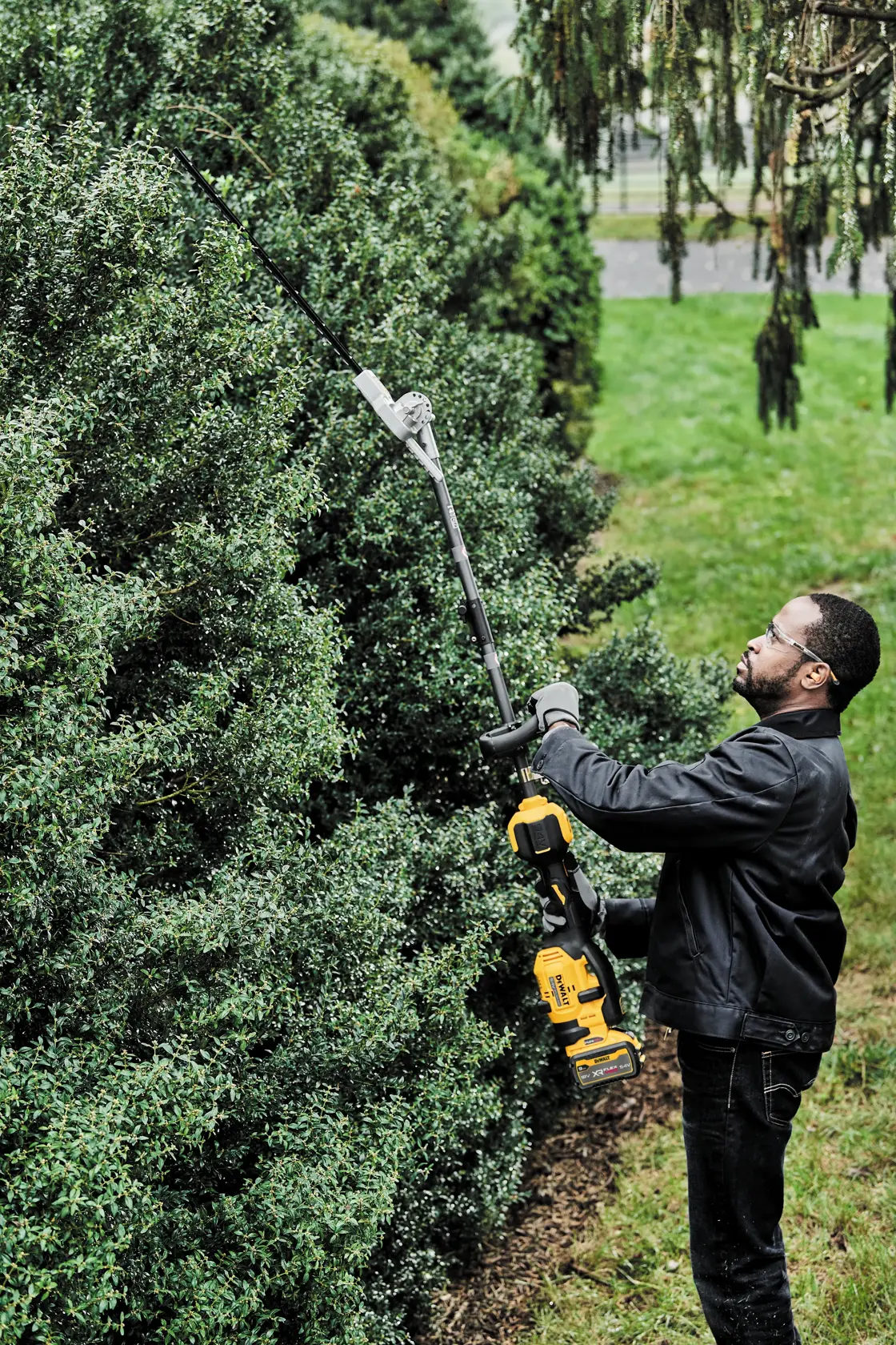 Person uses DEWALT hedge trimmer. SKUs: DCMASPH6N, DCZ65713X1-XE, DCMASPH6N-XJ. Outdoor scene.