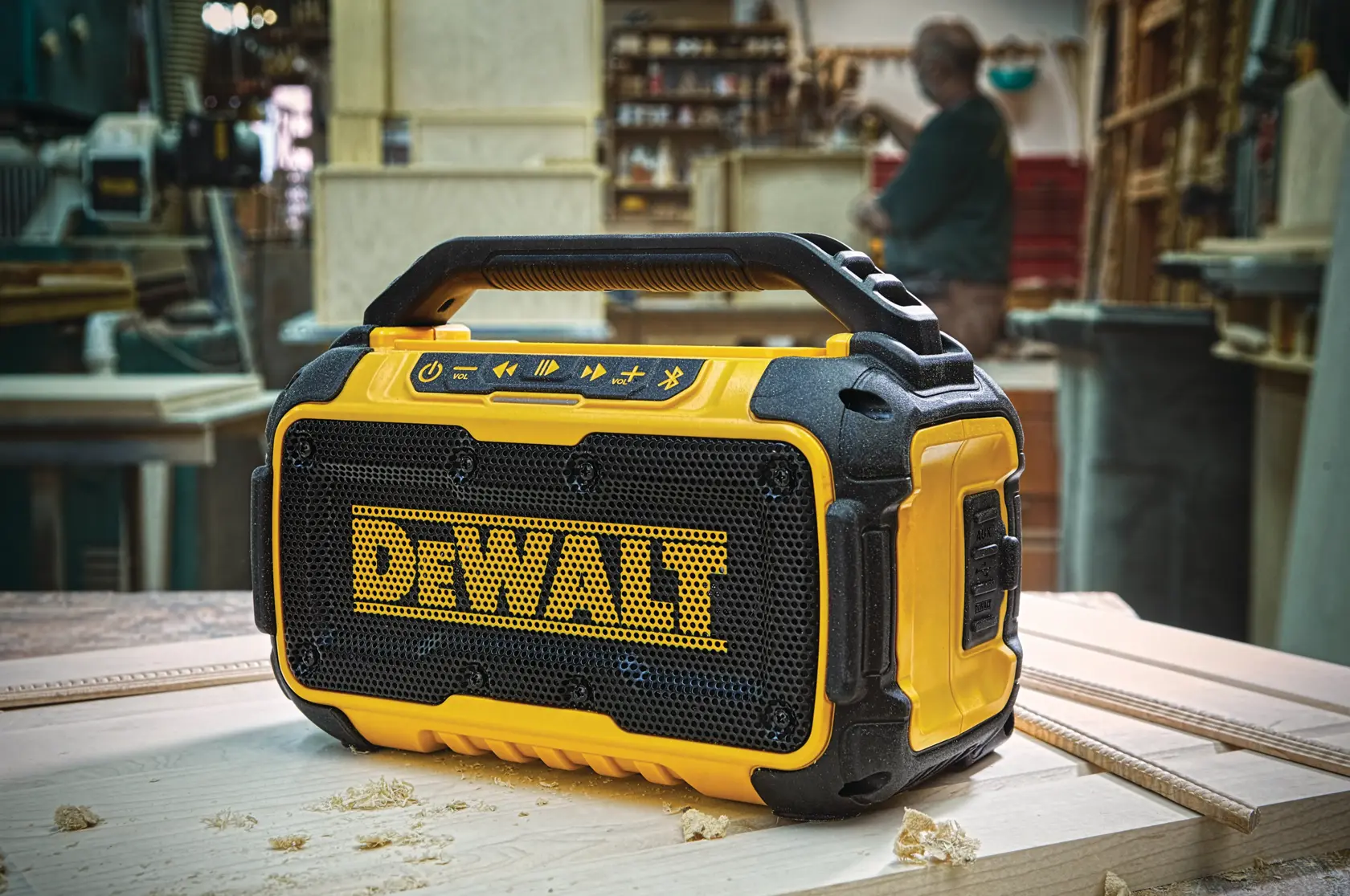 DEWALT portable Bluetooth speaker on a workbench in a workshop setting.