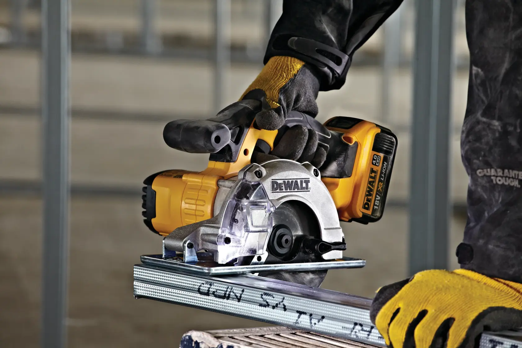 Sierra inalámbrica DEWALT para metal en uso, trabajador con guantes y protección, cortando perfil de acero.