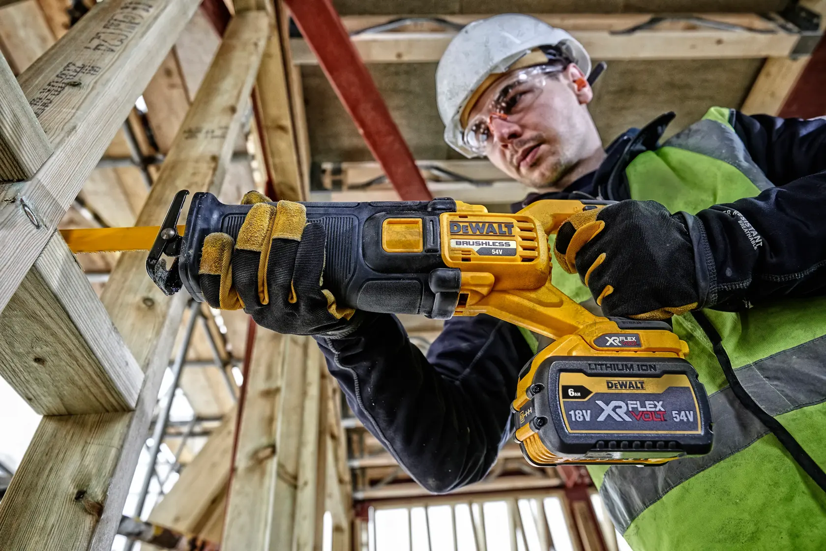 Trabajador utiliza sierra recíproca DEWALT DCS389T2 inalámbrica en estructura de madera.