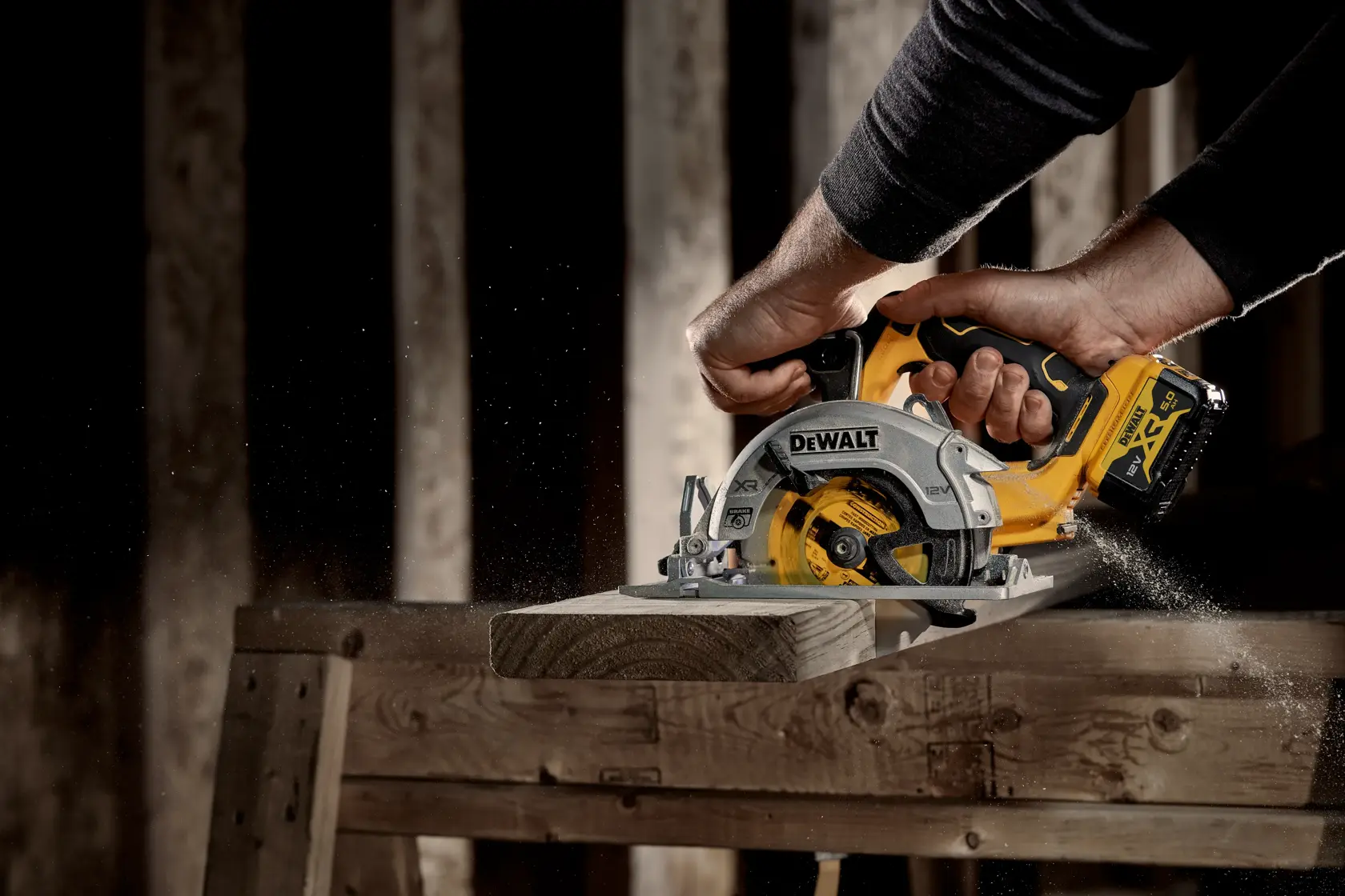 Persona corta madera con sierra circular inalámbrica DEWALT, aserrín sobre el banco de trabajo.