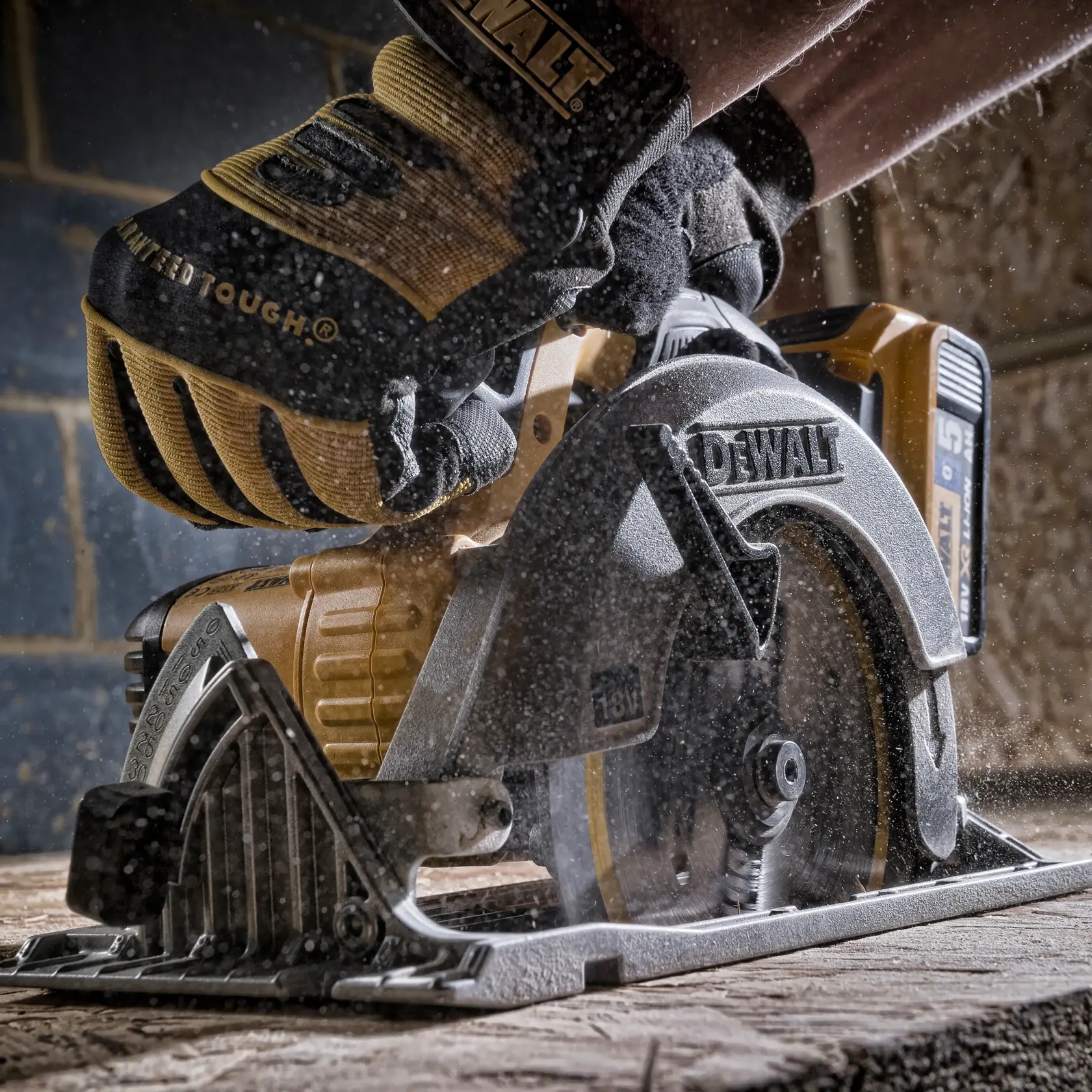 Mano guantata che usa una sega circolare DEWALT per tagliare legno in un ambiente polveroso.