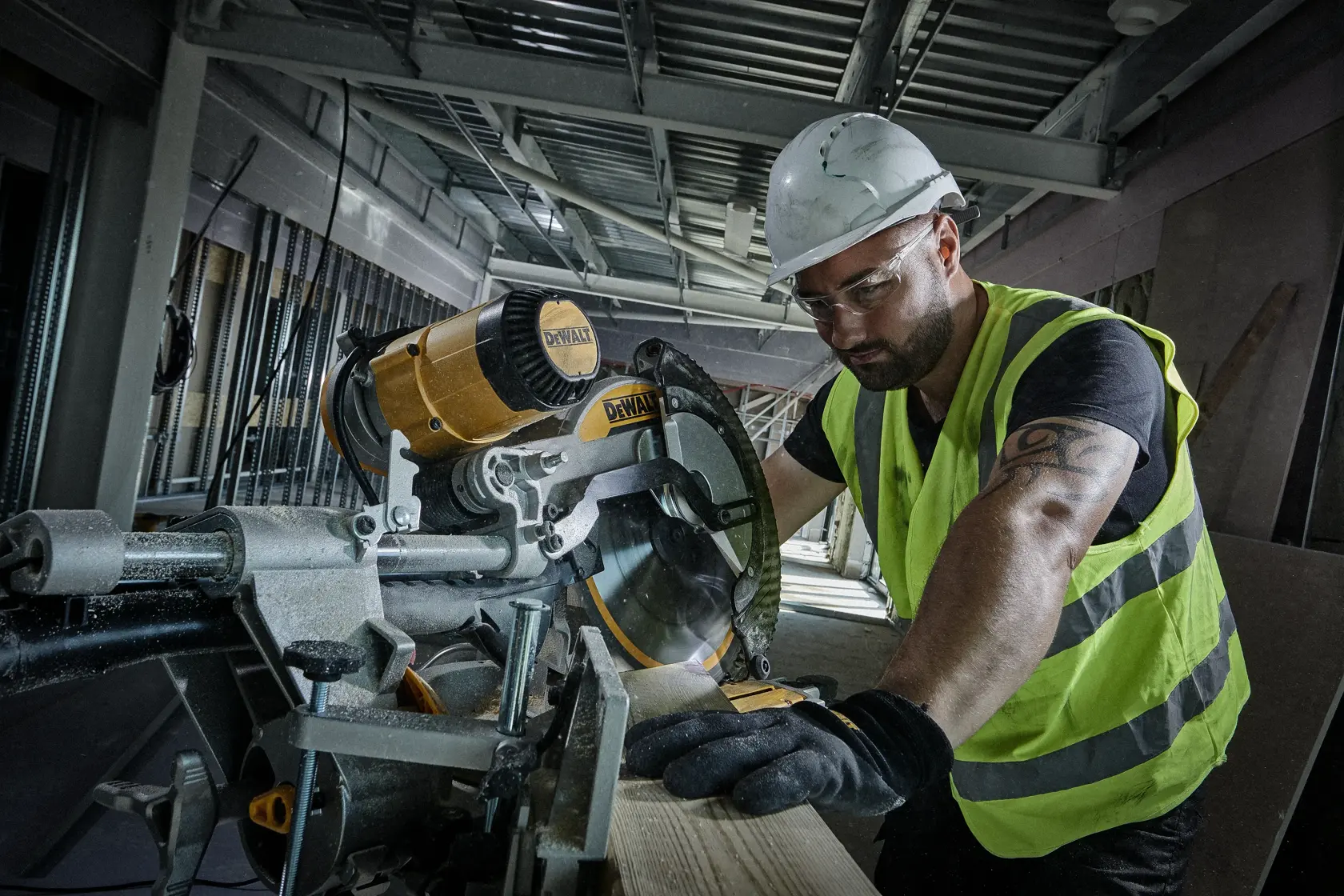 Arbeiter sägt Holz mit DEWALT Kreissäge auf Baustelle, trägt Sicherheitsausrüstung und Warnweste.