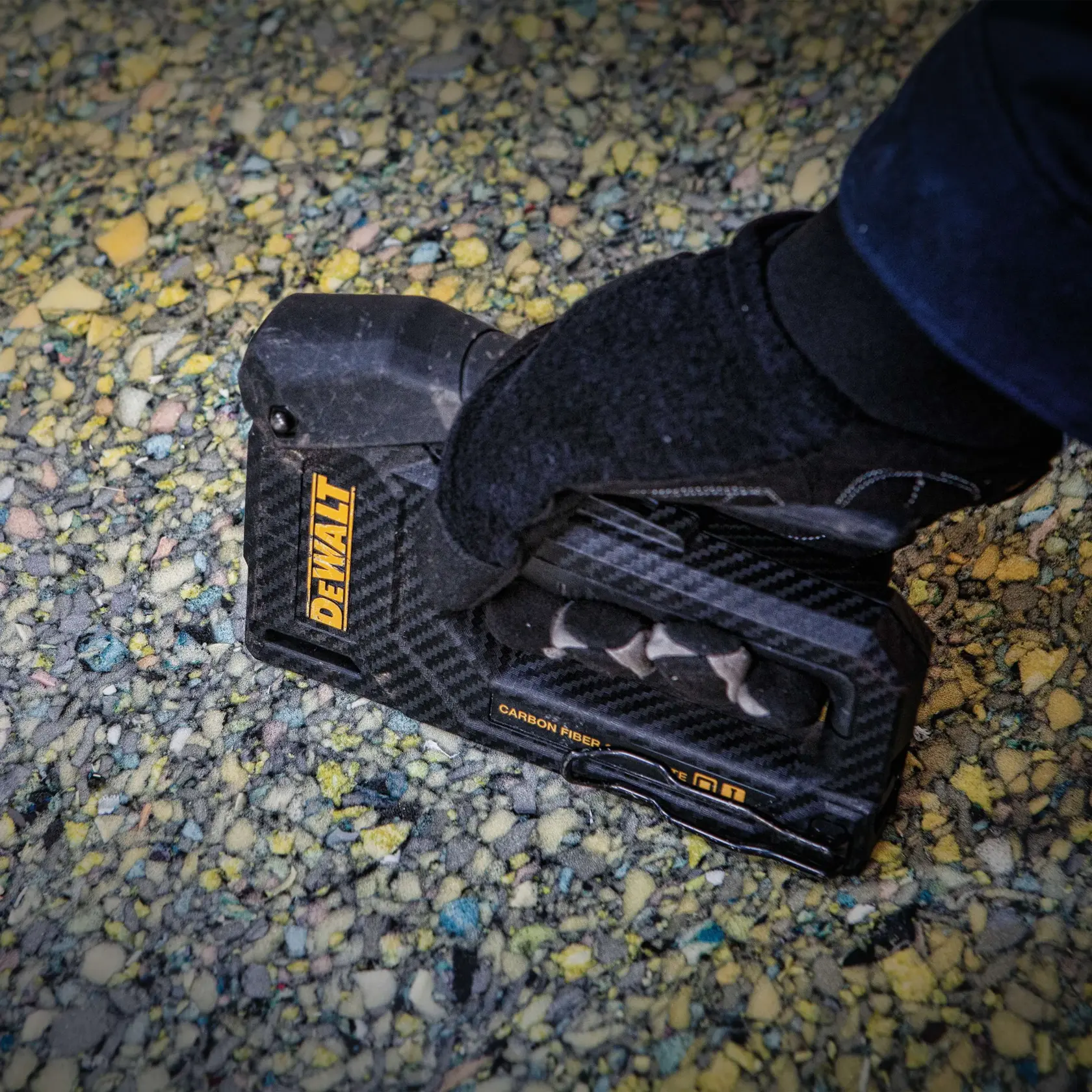 Carbon Fiber Composite Staple Gun being used to staple underlay on  wall outside.
