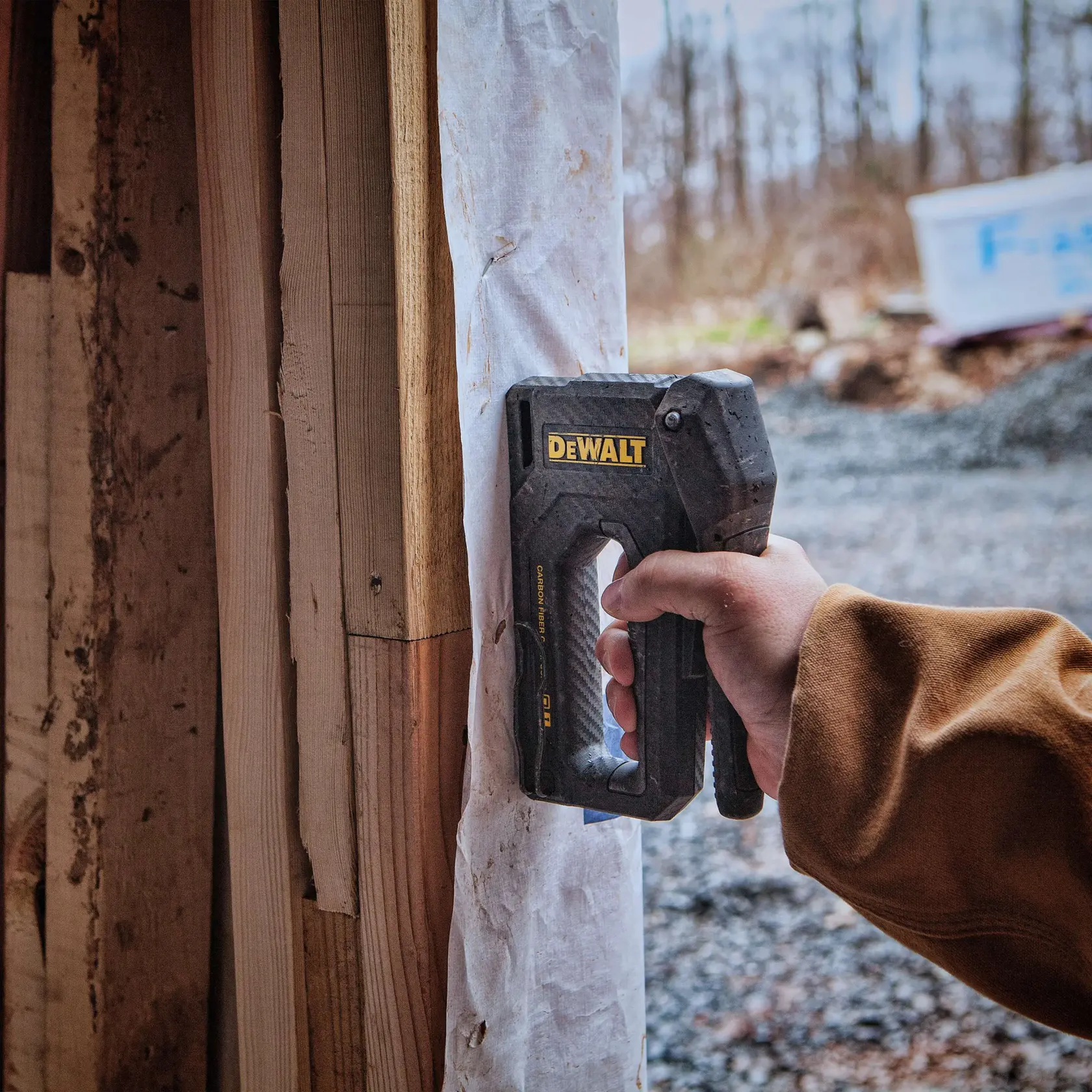 Carbon Fiber Composite Staple Gun being used to staple underlay on  wall.